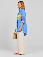 Glenda relaxed tunic in cornflower blue with yellow and violet stripes, side view showing the relaxed fit