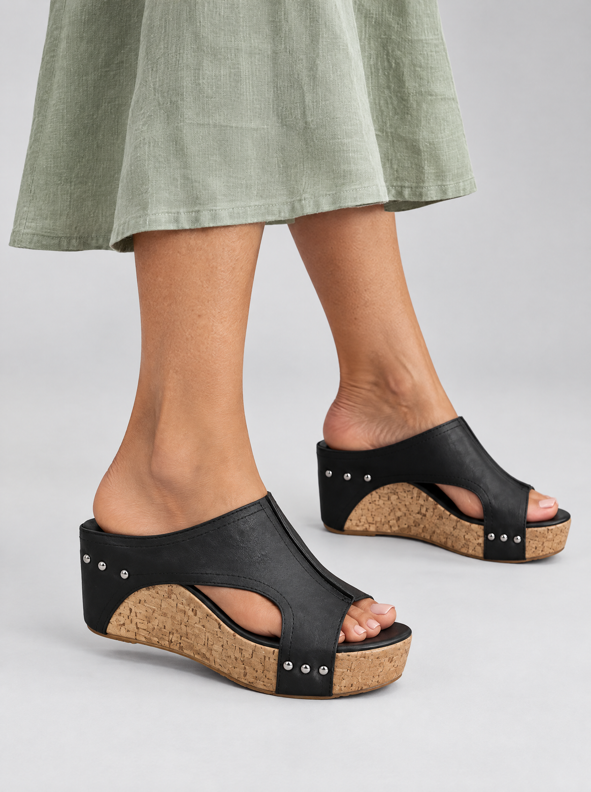 Melissa sandals in black, worn with a sage green linen dress
