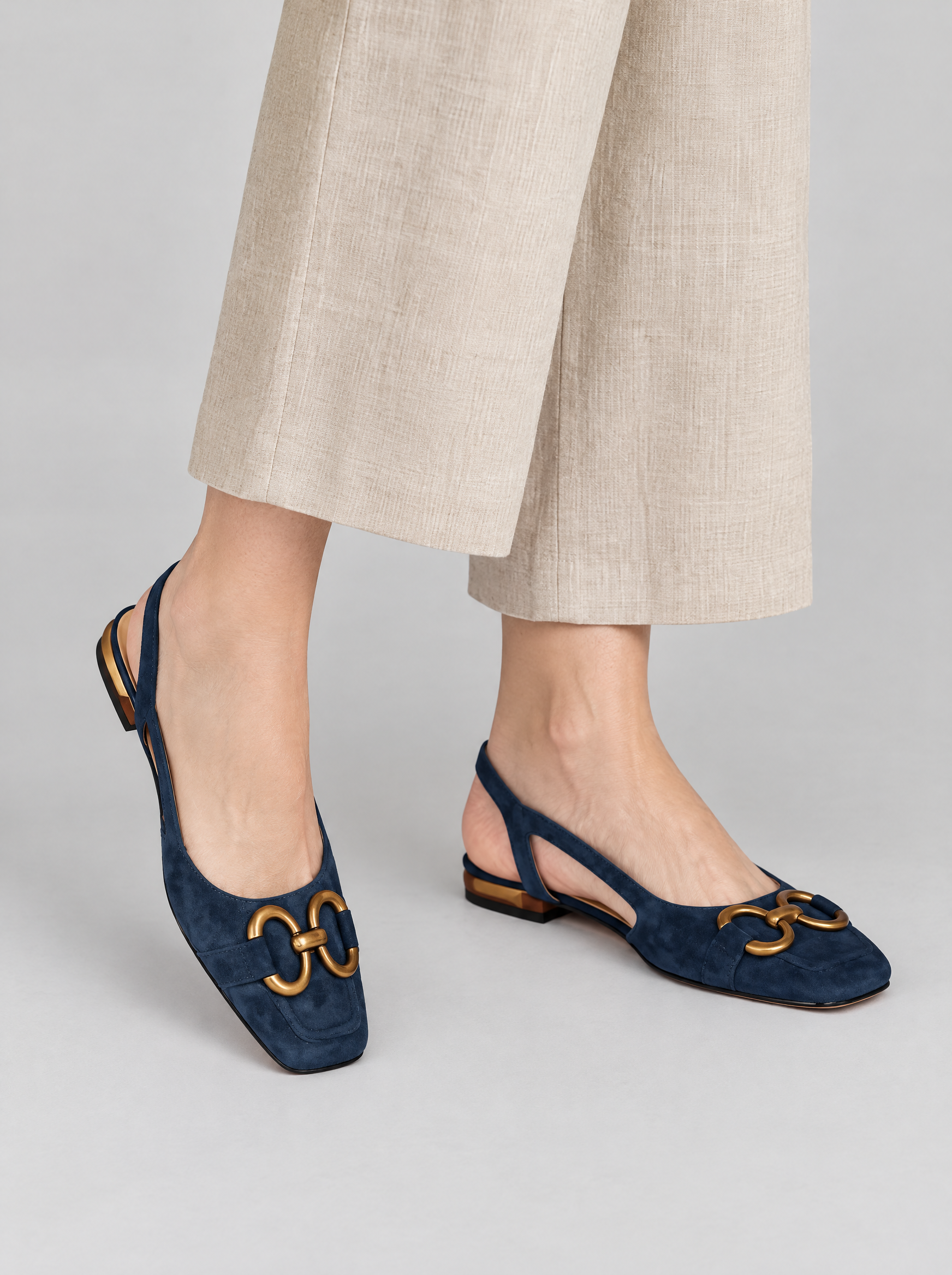 Daphne sandals in dark blue, worn with beige linen trousers