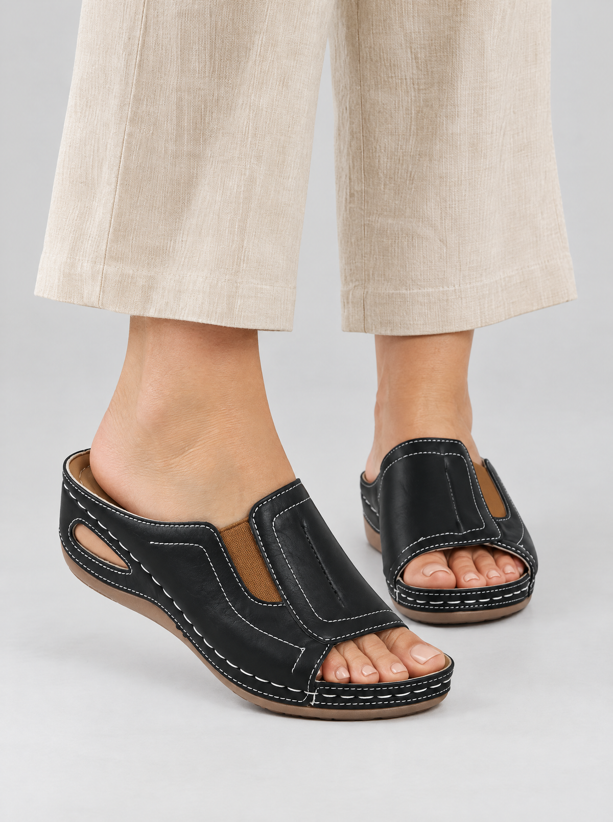 Tessa sandals in black, worn with beige linen trousers