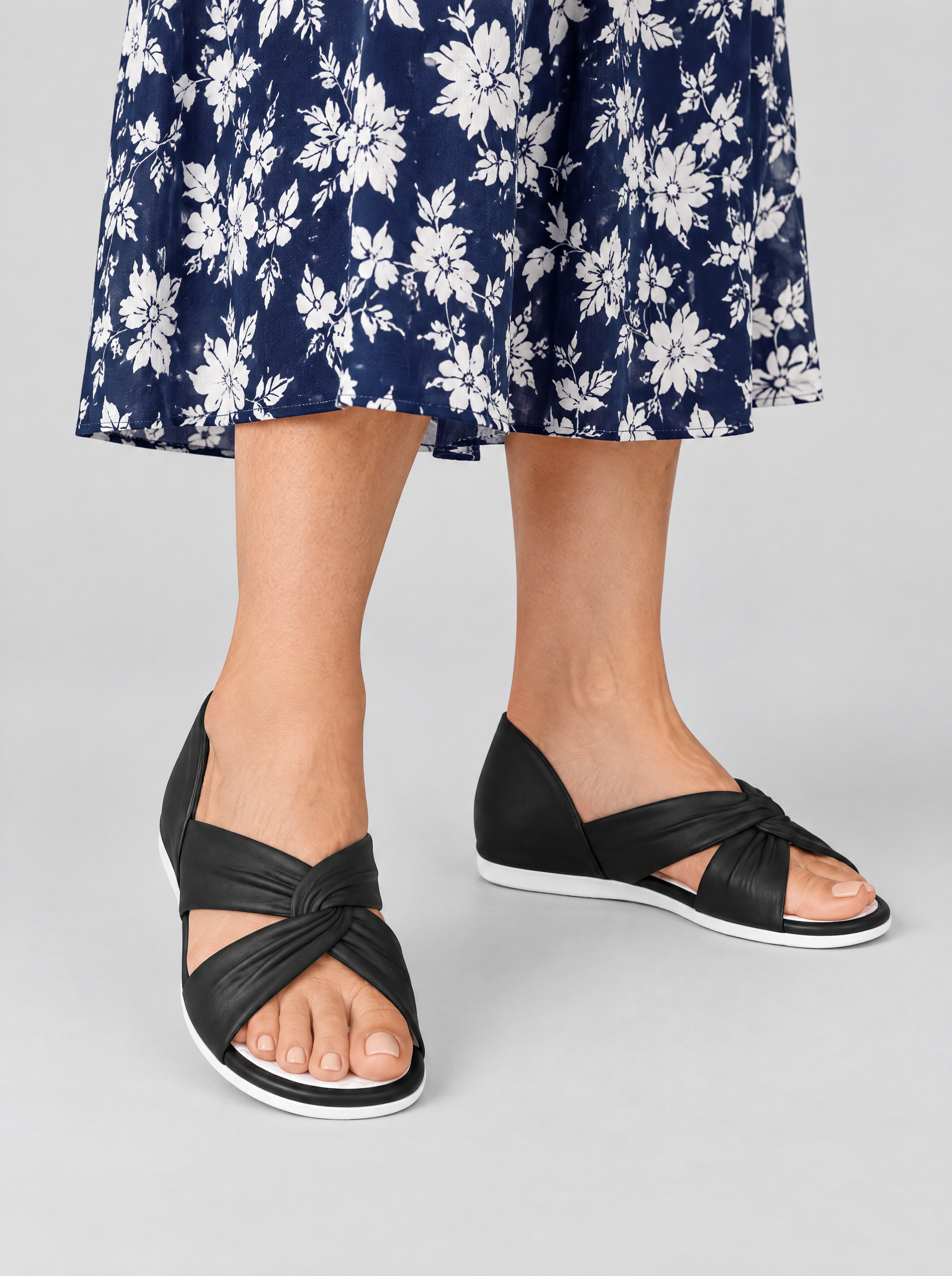 Anna sandals in black, worn with a navy and white floral dress